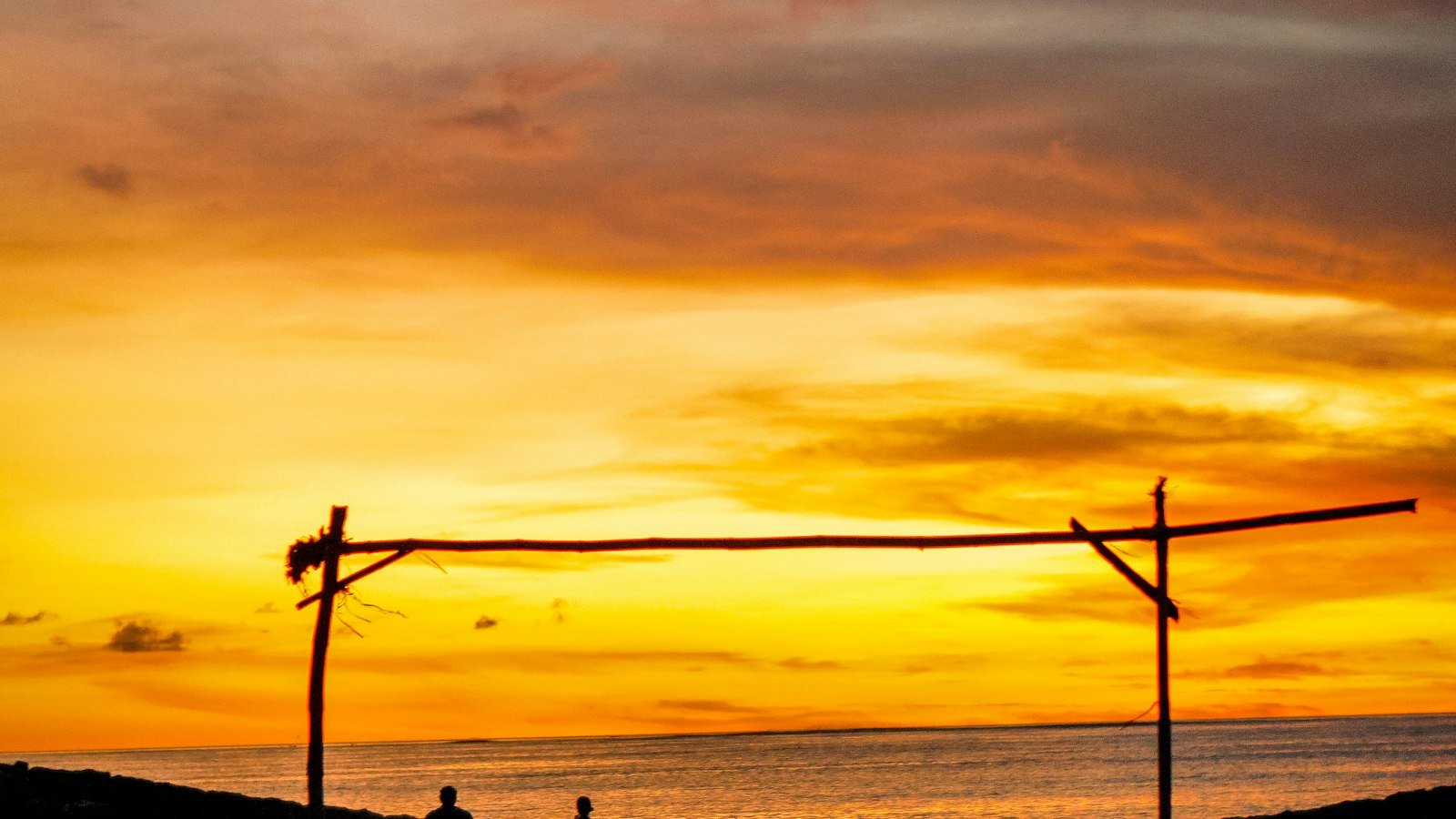 Rede montada na praia ao pôr do sol