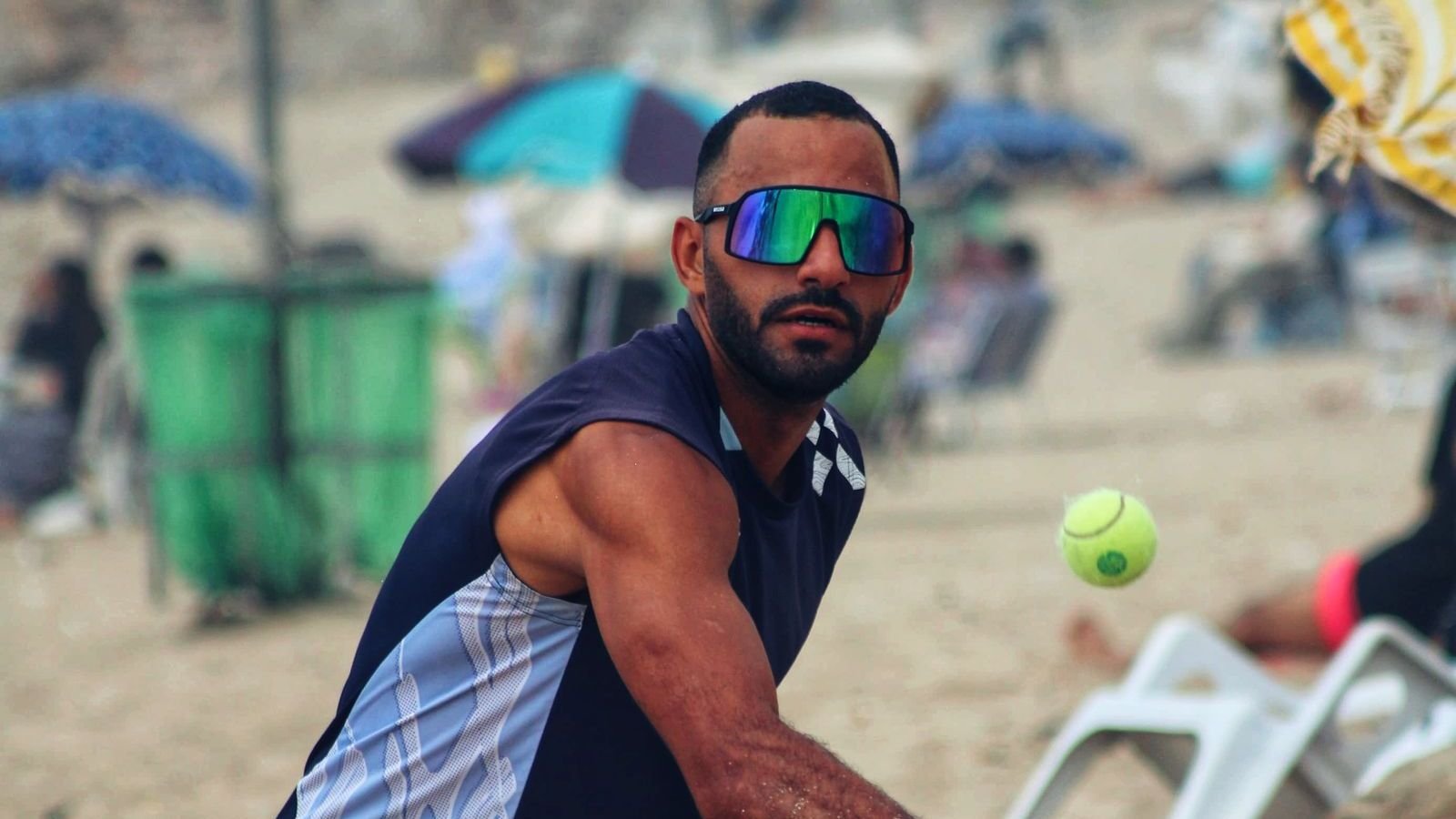 Jogador de beach tênis na praia, olhando para a bola